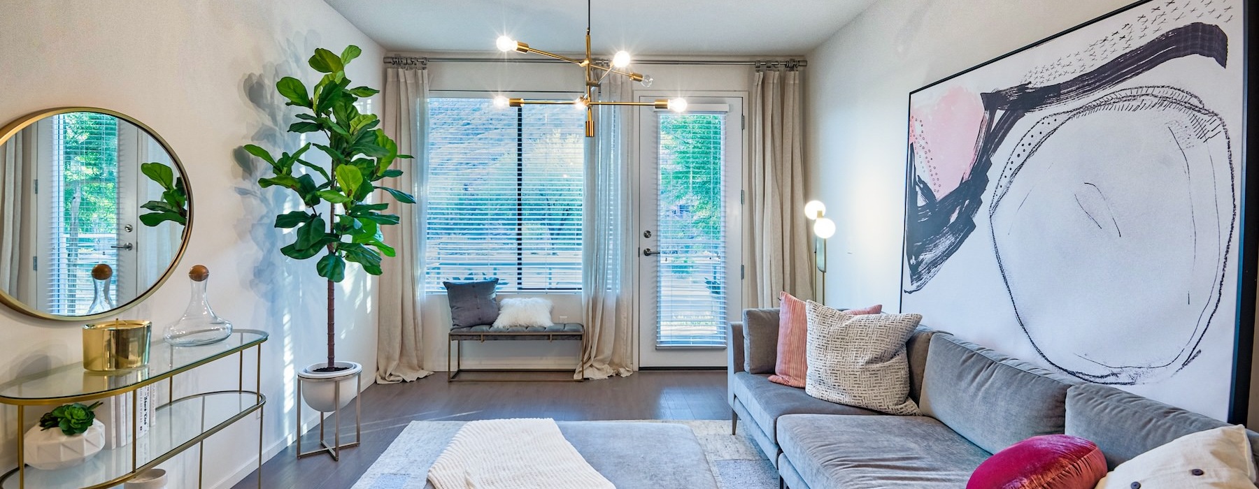 living room with a large couch, plants and windows