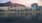 a body of water with buildings and a hill in the background