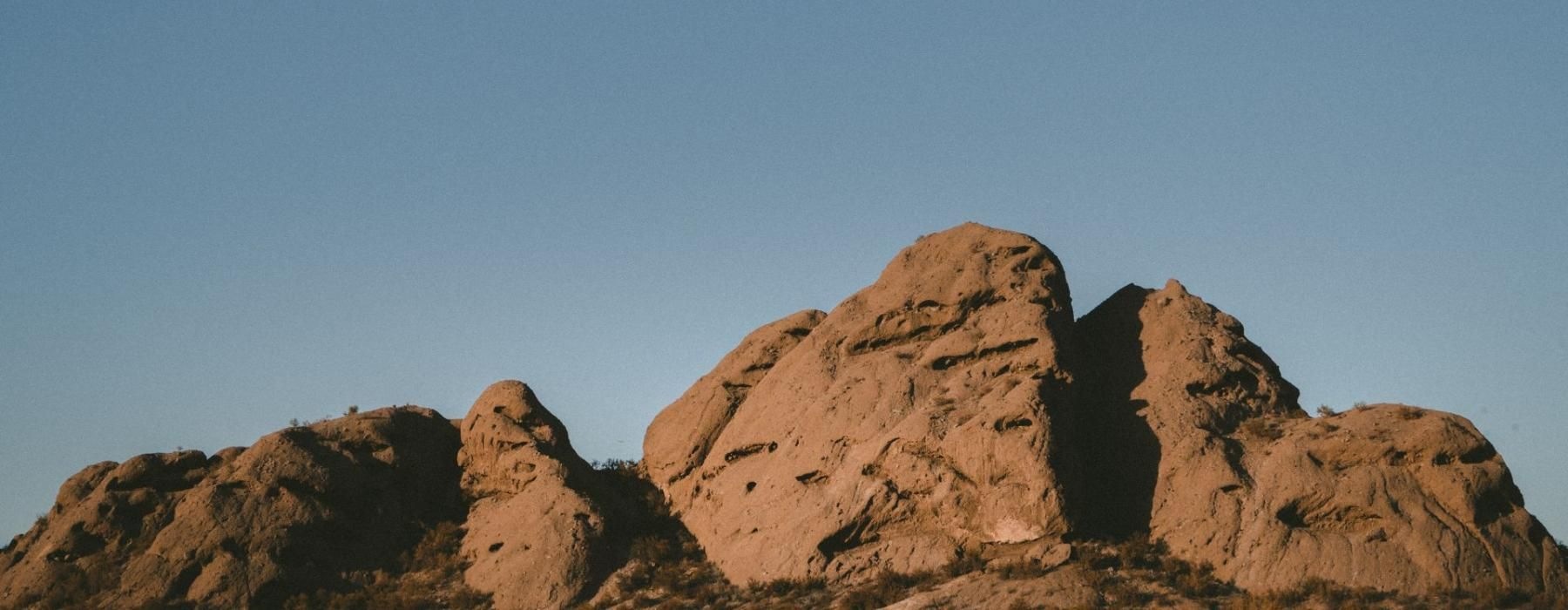 a rocky mountain with a blue sky